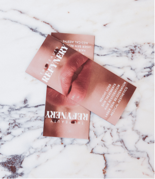 The Beauty Refinery brochures displayed on a marble surface